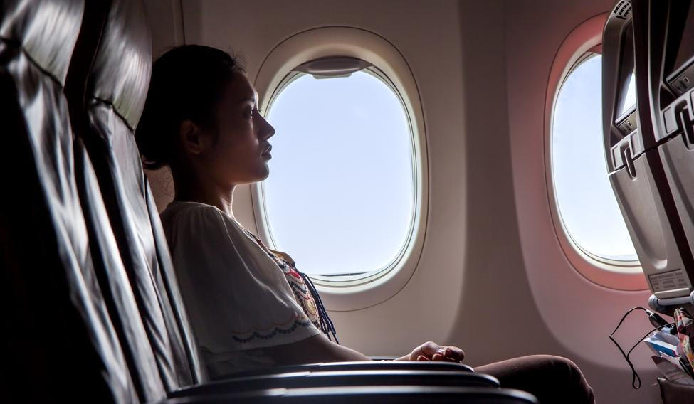 Woman,Sitting,In,A,Flying,Aircraft,And,Watching,The,Monitor.
