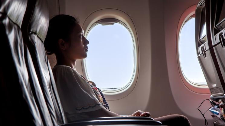 Woman,Sitting,In,A,Flying,Aircraft,And,Watching,The,Monitor.