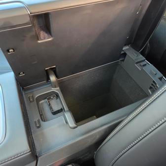 Odkládací box mezi sedadly je možné otevírat z obou stran.