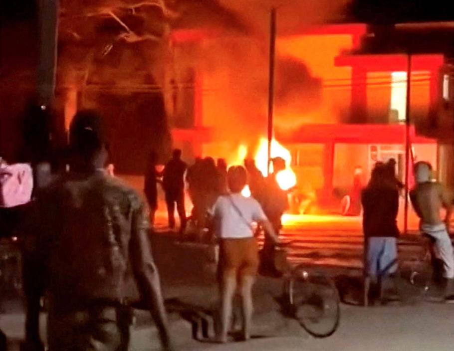 Demonstranti na Kubě zapalují před budovou Komunistické strany odpadky a další předměty.