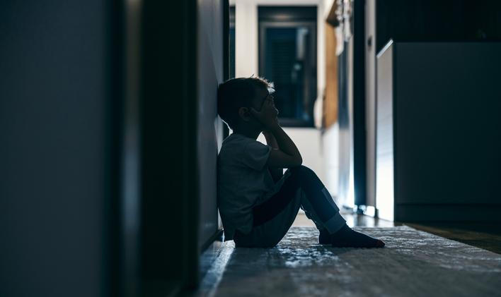 Side,View,Of,A,Lonely,Child,Sitting,In,A,Dark