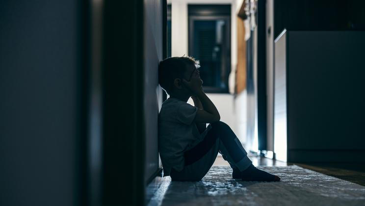 Side,View,Of,A,Lonely,Child,Sitting,In,A,Dark