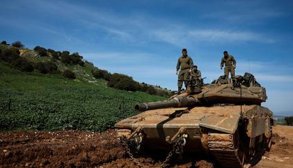 Israeli soldiers stand on a tank on the Israeli side of the border with Lebanon, amid escalation between Hezbollah and Israel