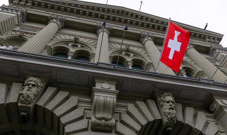 ARCHIVNÍ FOTO: Švýcarská vlajka visí na budově švýcarského parlamentu (Bundeshaus) v Bernu