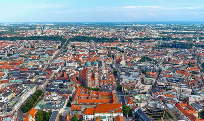 Letecký pohled na mnichovské Altstadt s Frauenkirche, město s vysokými tržními nájmy a cílenými programy dostupného bydlení.