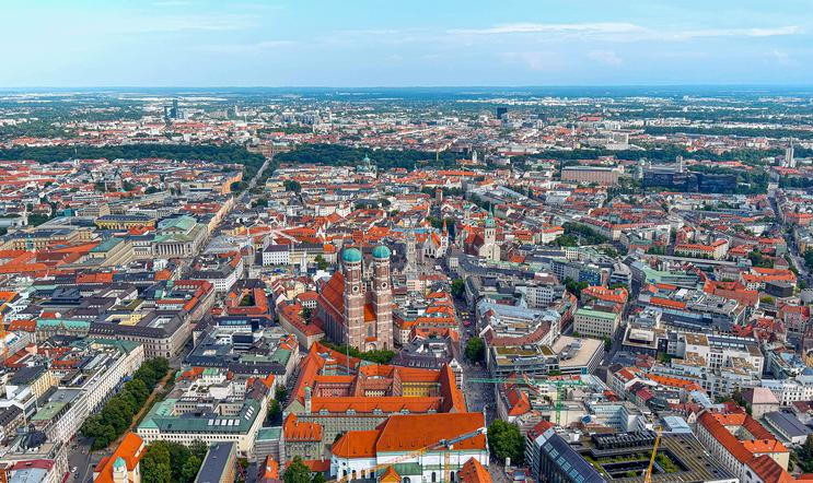 Letecký pohled na mnichovské Altstadt s Frauenkirche, město s vysokými tržními nájmy a cílenými programy dostupného bydlení.