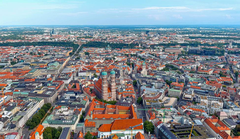 Letecký pohled na mnichovské Altstadt s Frauenkirche, město s vysokými tržními nájmy a cílenými programy dostupného bydlení.