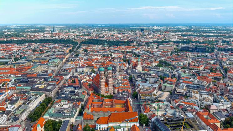 Letecký pohled na mnichovské Altstadt s Frauenkirche, město s vysokými tržními nájmy a cílenými programy dostupného bydlení.