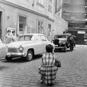 Takto to vypadalo na Hradčanském náměstí už po okupaci v roce 1969. Žena fotí kontrast mezi tehdy relativně moderním wartburgem a jedním z předválečných strojů.