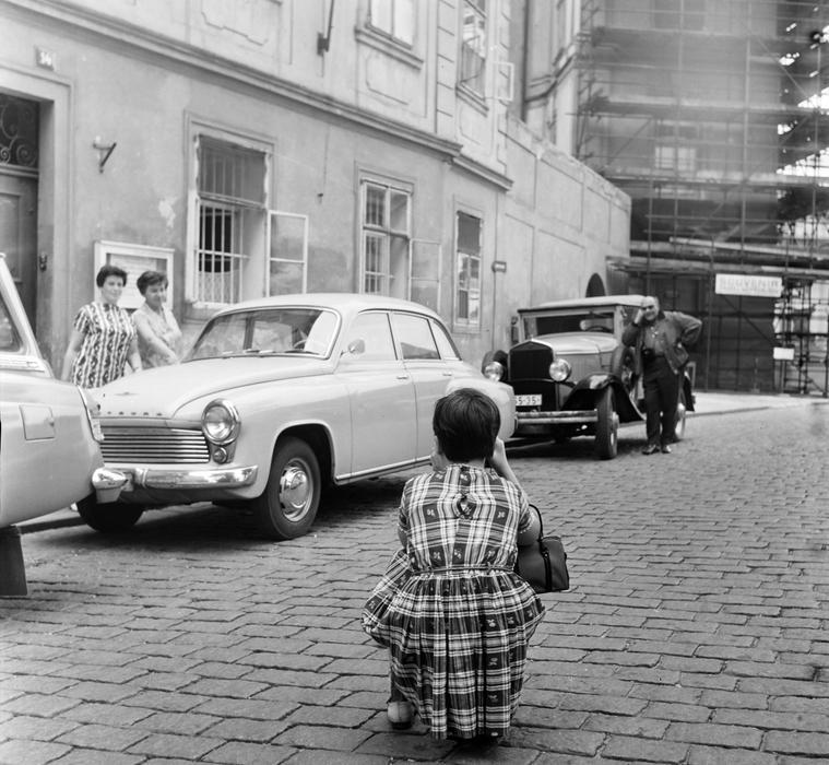 Takto to vypadalo na Hradčanském náměstí už po okupaci v roce 1969. Žena fotí kontrast mezi tehdy relativně moderním wartburgem a jedním z předválečných strojů.