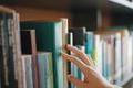 Close,Up,Hand,Search,For,Book,On,Bookshelves,In,The