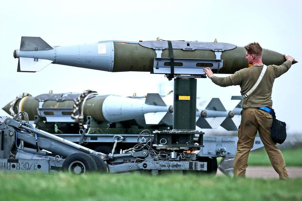 Members of the ground crew handle munitions at RAF Fairford airbase, in Fairford