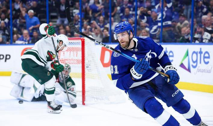 Erik Černák (81) z Tampy Bay slaví gól, zatímco hráči Minnesoty hledí na rozbitou kameru v brance