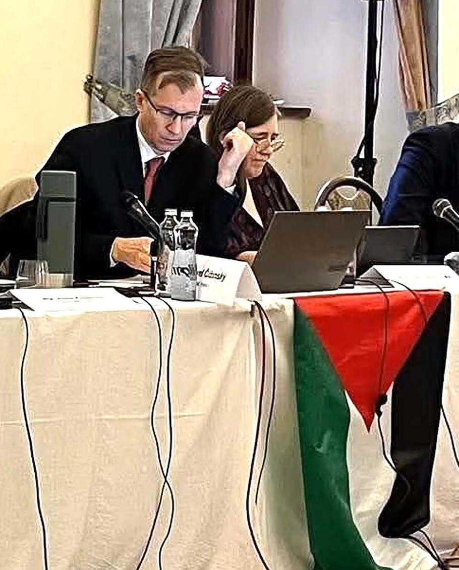 Pavel Čižinský s vyvěšenou palestinskou vlajkou v prosinci 2025 na zasedání zastupitelstva Prahy 1.
