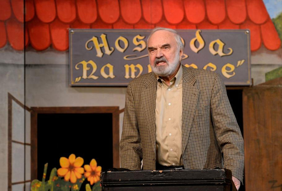 Zdeněk Svěrák před kulisami ke hře Divadla Járy Cimrmana Hospoda na mýtince.