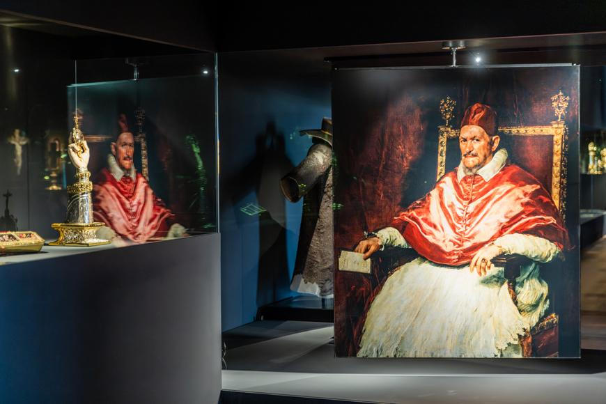 Korunovační kříž vedle Kiefera. Hrad vystavuje svatovítský poklad se současnými díly