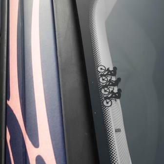 Symbol třech cyklistů odkazuje na angažmá v závodu Tour de France i minulost značky.