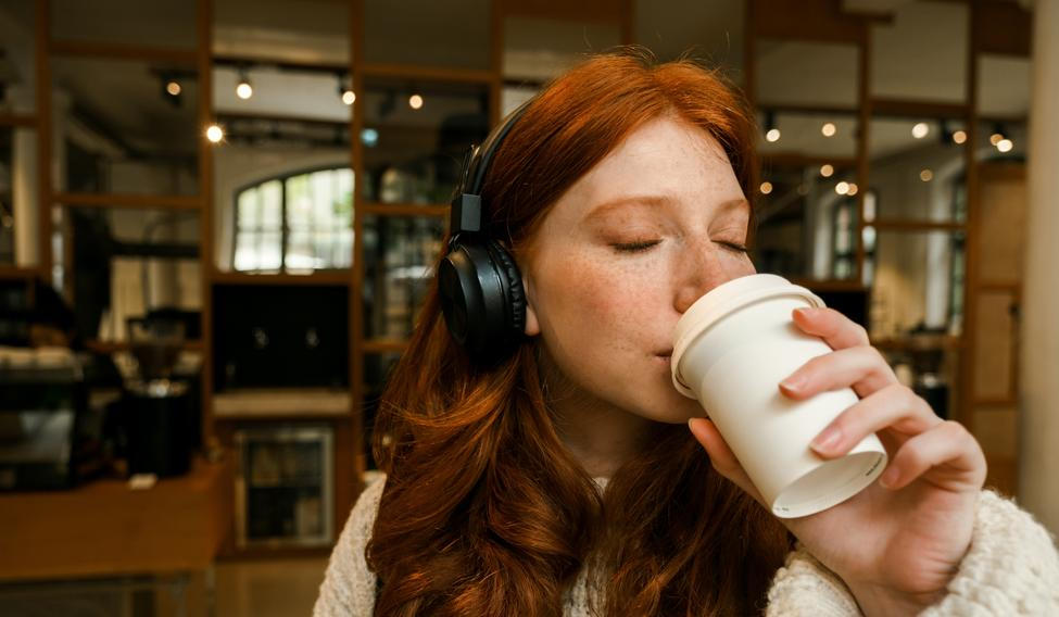 Young,Redhead,Girl,Wearing,Sweater,Listening,Music,With,Headphones,And