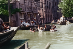 Zaplavené ulice s čluny a lidmi ve vodě, Hankou (Wuhan), Čína, září 1931. Kolorováno