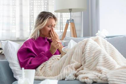 Young Woman Caught Cold Or Flu Illness. Portrait Of Unhealthy Girl blowing her nose