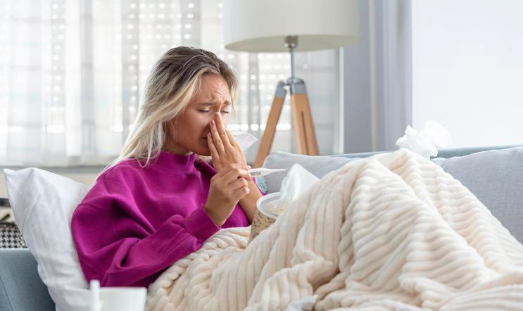 Young Woman Caught Cold Or Flu Illness. Portrait Of Unhealthy Girl blowing her nose