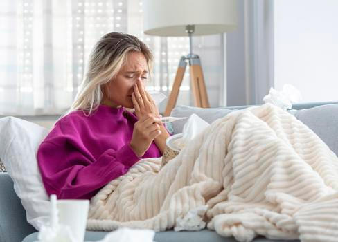 Young Woman Caught Cold Or Flu Illness. Portrait Of Unhealthy Girl blowing her nose
