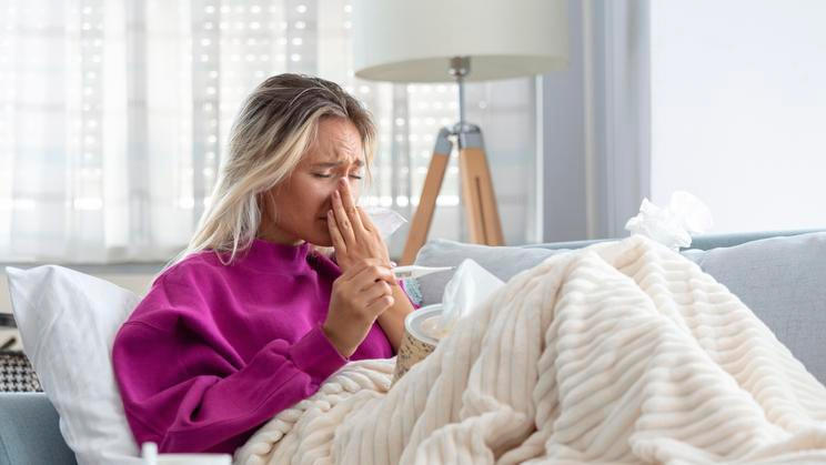 Young Woman Caught Cold Or Flu Illness. Portrait Of Unhealthy Girl blowing her nose