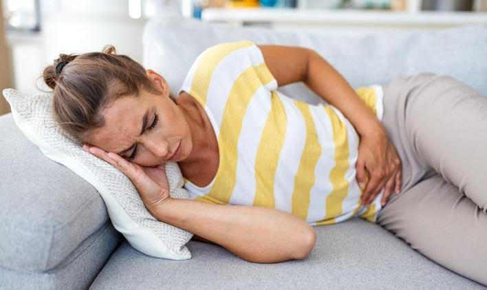 Woman,Lying,On,Sofa,With,Stomach,Pain,And,Nausea.,Abdominal