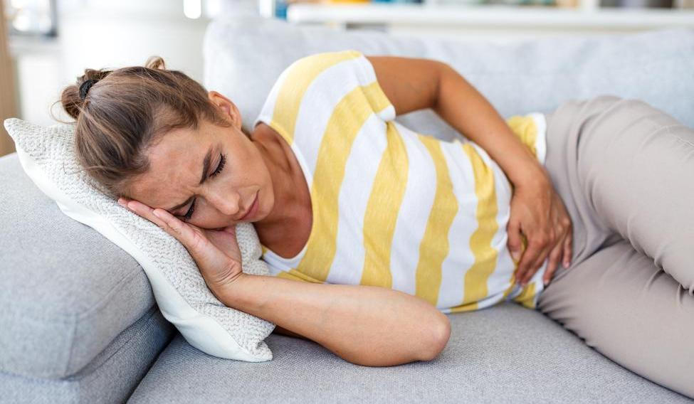 Woman,Lying,On,Sofa,With,Stomach,Pain,And,Nausea.,Abdominal