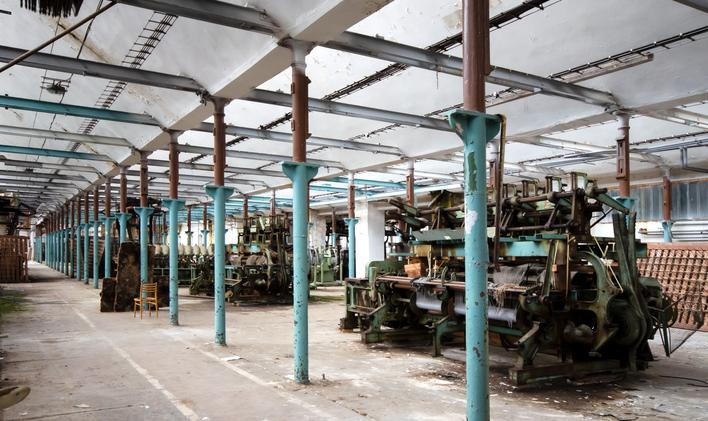 Pohled do výrobní haly s řadami odstavených strojů.