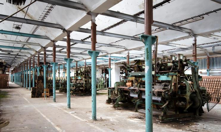 Pohled do výrobní haly s řadami odstavených strojů.