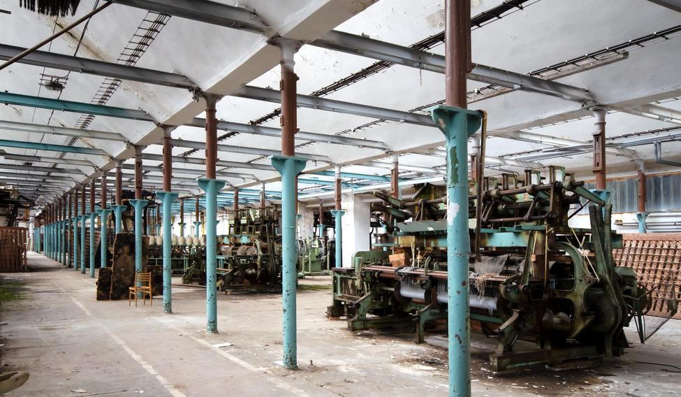 Pohled do výrobní haly s řadami odstavených strojů.