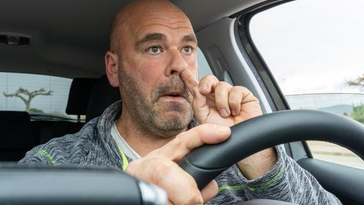 Middle,Aged,Man,Picking,His,Nose,Driving,A,Car.