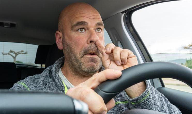 Middle,Aged,Man,Picking,His,Nose,Driving,A,Car.