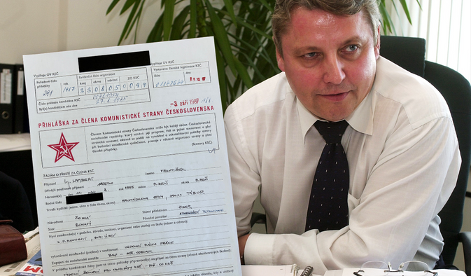 František Lambert na archivním snímku z roku 2004. Vedle něj kopie jeho přihlášky do normalizační KSČ – kandidátem na členství se stal v roce 1985, 28. prosince 1987 dostal rudou knížku.