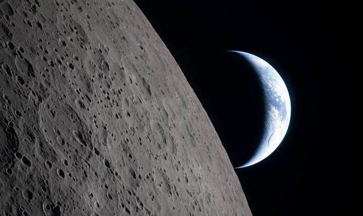 A view of Earth, partially hidden by the Moon, photographed through the Orion spacecraft window