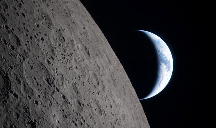 A view of Earth, partially hidden by the Moon, photographed through the Orion spacecraft window