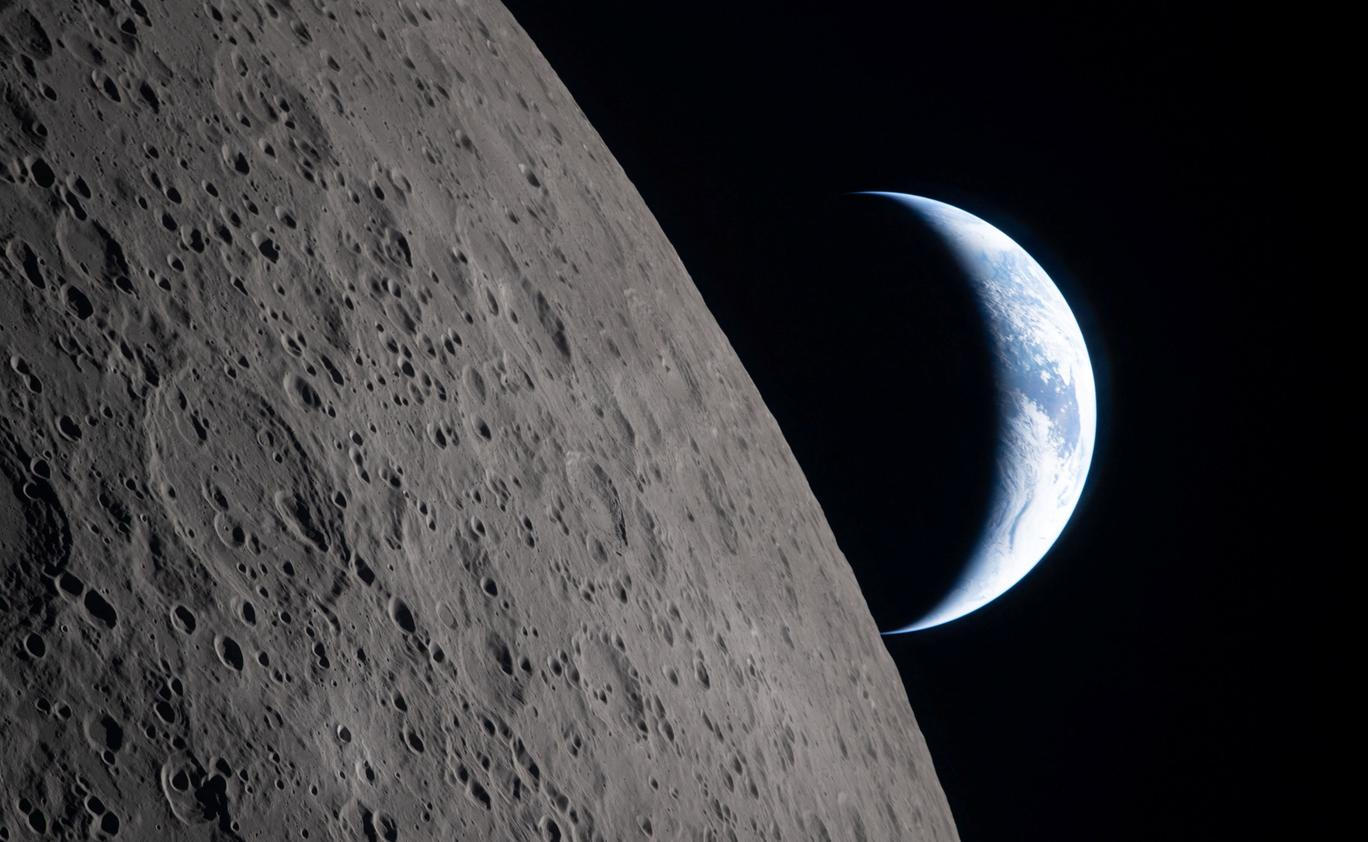 A view of Earth, partially hidden by the Moon, photographed through the Orion spacecraft window