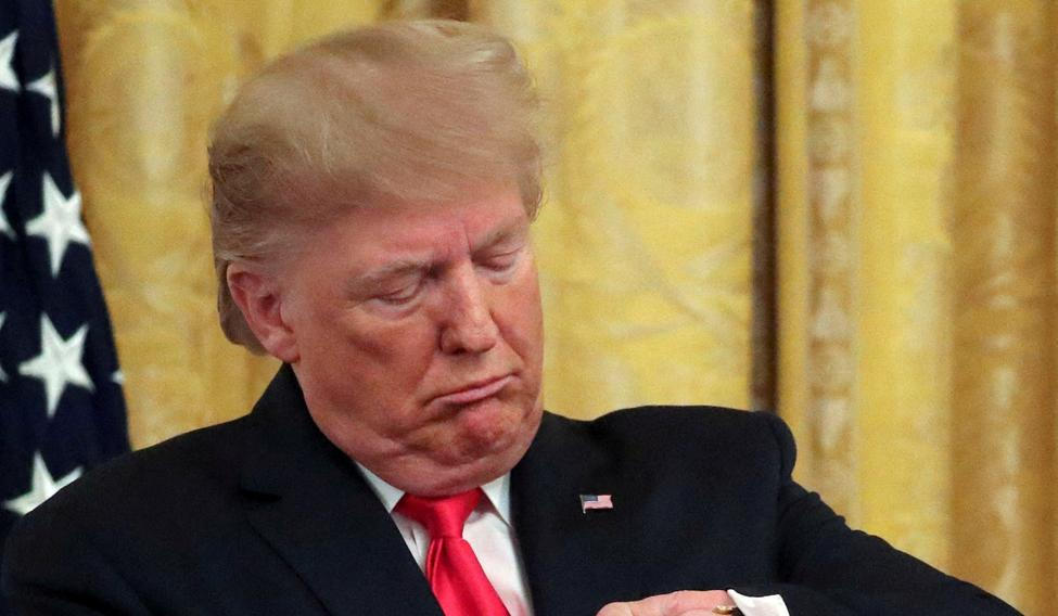FILE PHOTO: U.S. President Trump checks his watch during an event in the East Room of the White House in Washington, D.C.