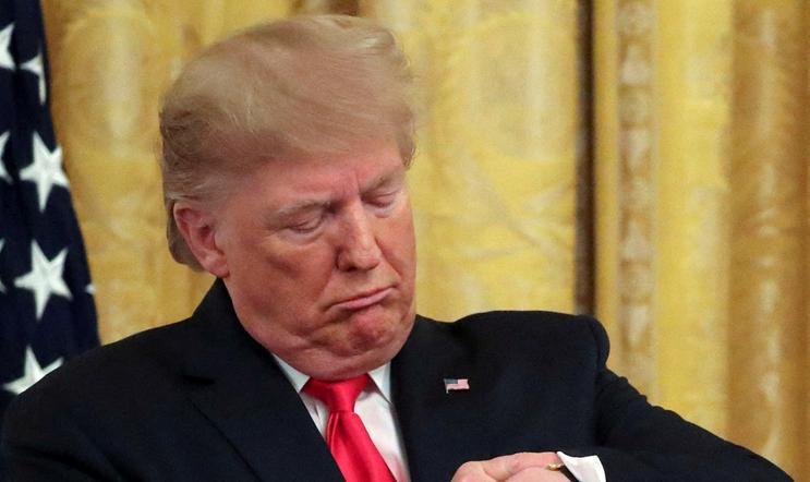 FILE PHOTO: U.S. President Trump checks his watch during an event in the East Room of the White House in Washington, D.C.