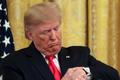 FILE PHOTO: U.S. President Trump checks his watch during an event in the East Room of the White House in Washington, D.C.