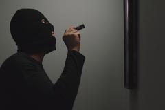 Thief,Climbs,Into,The,House,,Shines,A,Flashlight,On,The