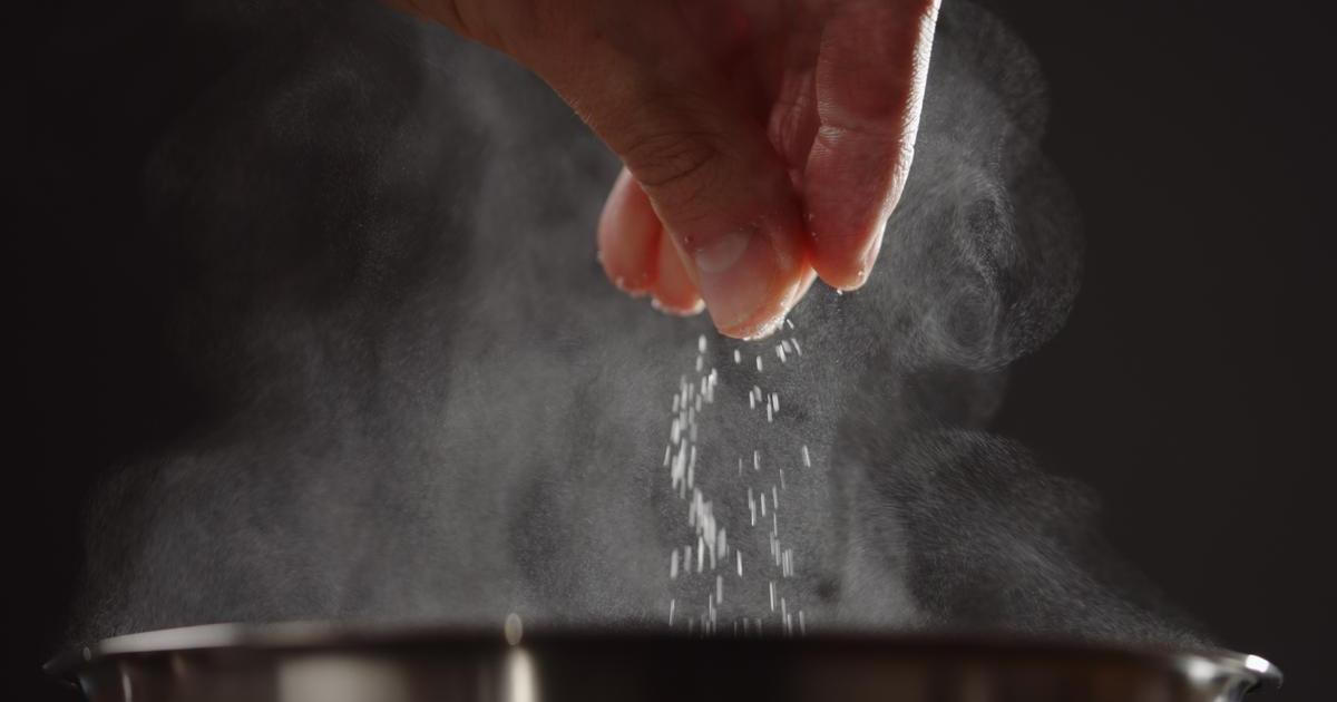 Man,Adding,Salt,To,Boiling,Water,In,Saucepan,With,Strong