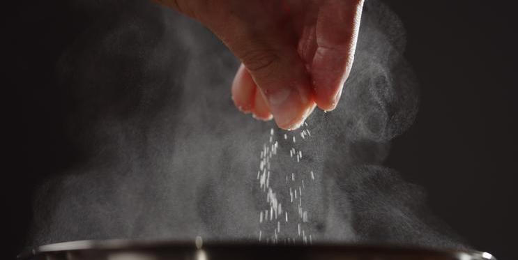 Man,Adding,Salt,To,Boiling,Water,In,Saucepan,With,Strong