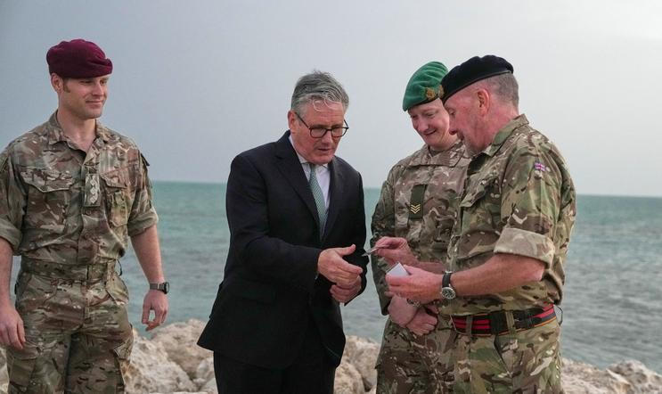 Britain's Prime Minister Keir Starmer meets military personnel on a beach in Bahrain