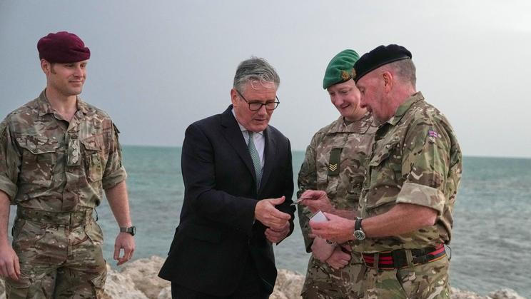 Britain's Prime Minister Keir Starmer meets military personnel on a beach in Bahrain