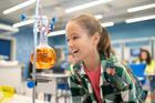 ["Girl with delight looking at flask in chemistry class"]