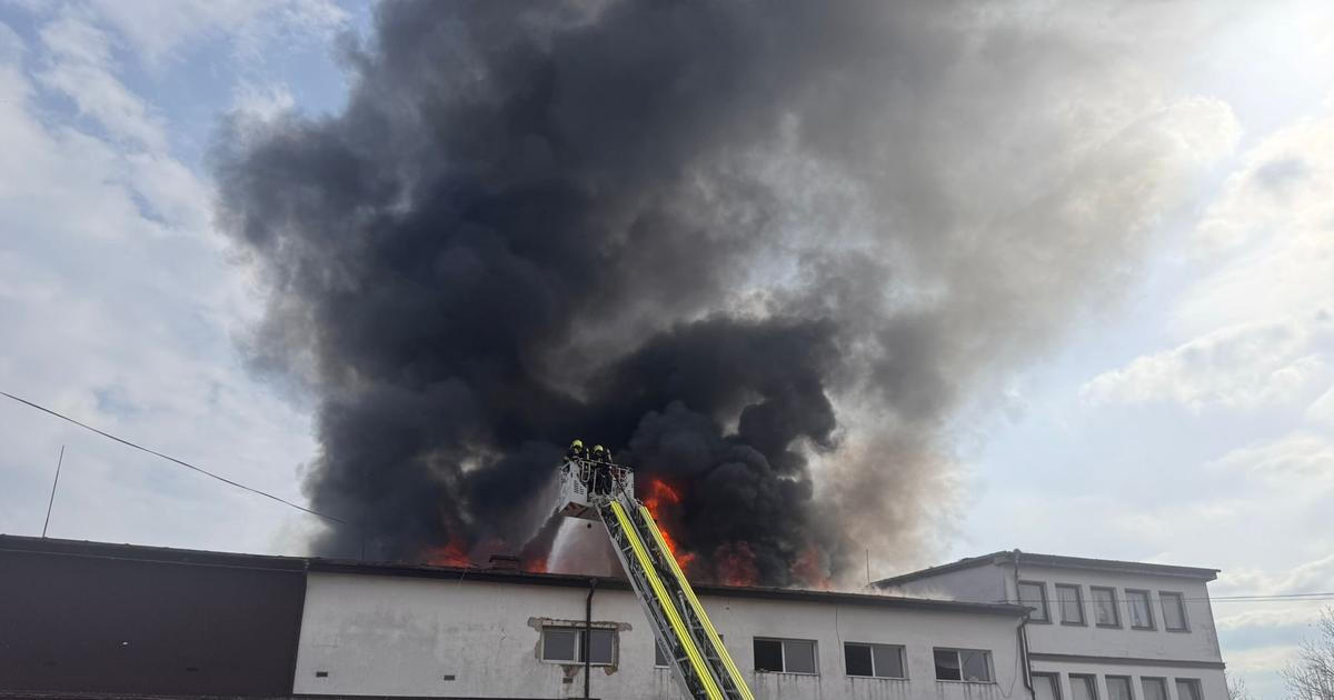 V Praze na Žižkově hoří střecha ubytovny, hasiči lidi zachraňují pomocí žebříků