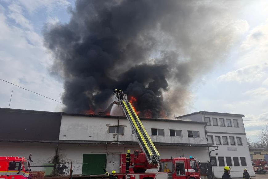 V Praze na Žižkově hoří střecha ubytovny, hasiči lidi zachraňují pomocí žebříků