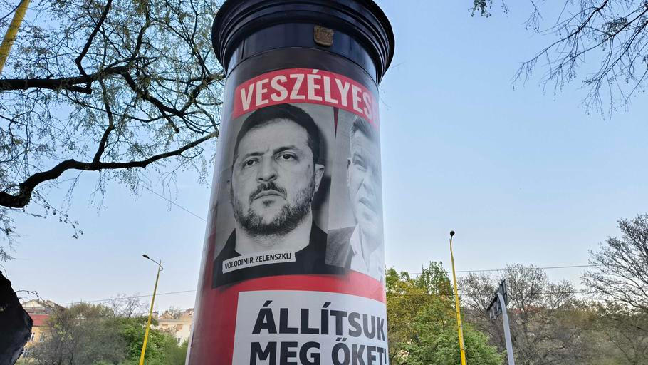 Plakát s šéfem Budanova – ukrajinským prezidentem Volodymyrem Zelenským vedle opozičního představitele Pétera Magyara, 11. dubna 2026.
